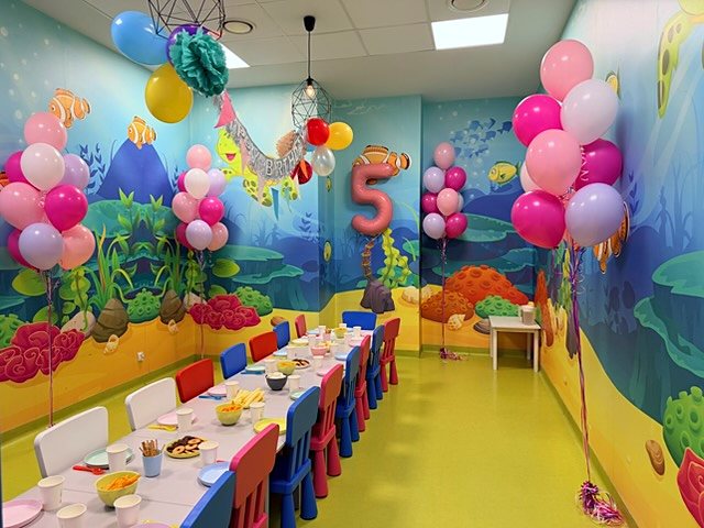Sala zabaw na 5. urodziny z bukietami balonów z helem wzdłuż stołu